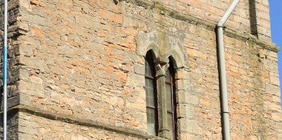 Close up of south face of tower, showing eroded stonework and mortar