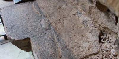 Close up of uncovered fragment of ancient headstone